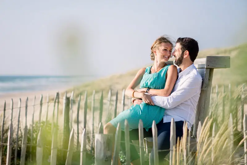 The couple sitting on a bench among the dune grasses in Lacanau
