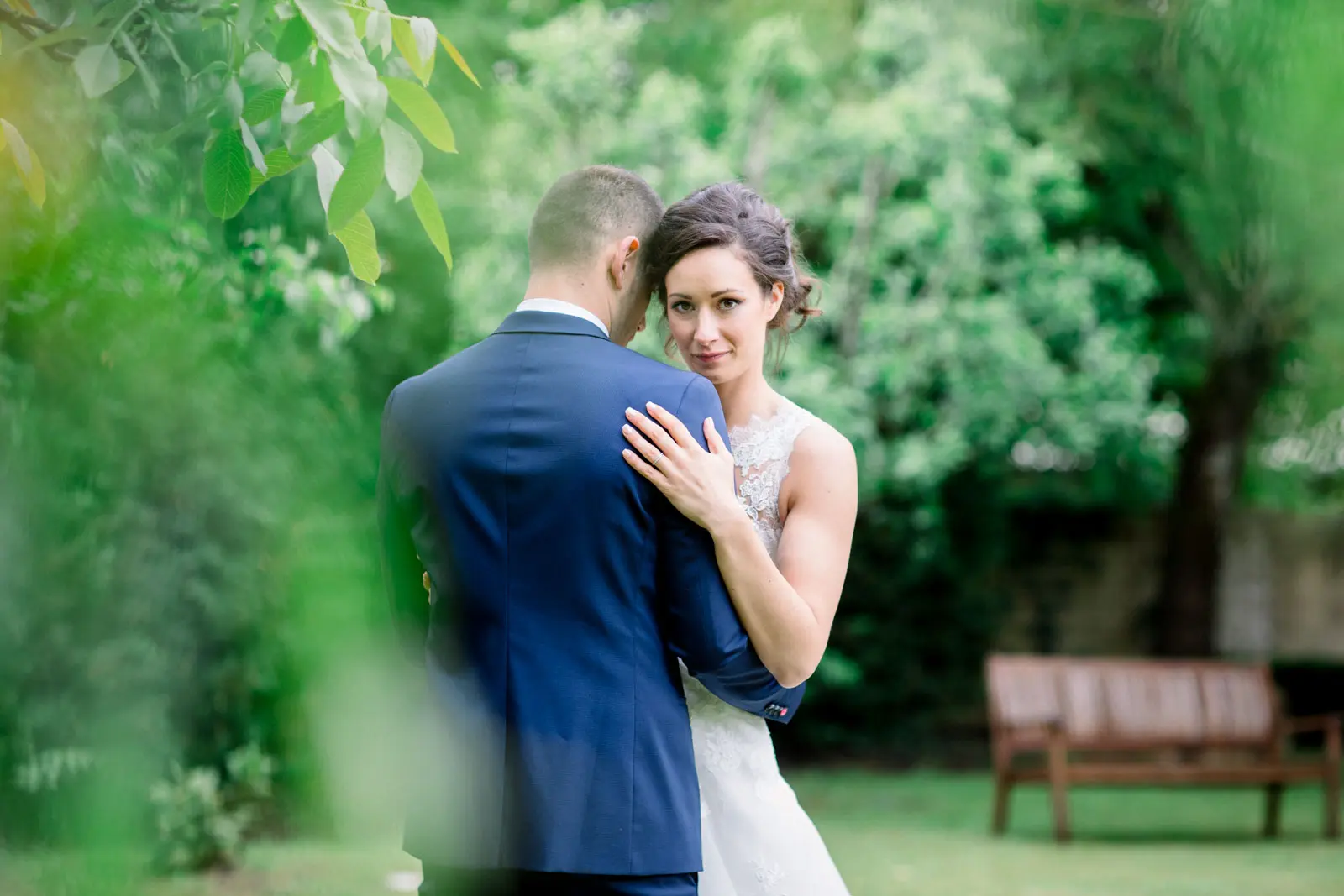 Mélissa and Adrien embracing in the lush garden of the Manoir de Saint-Gervais