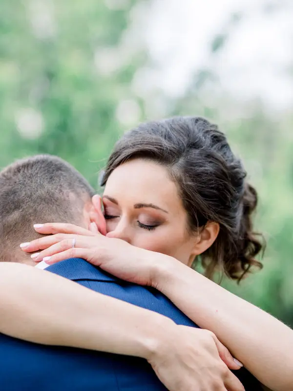 Bride with eyes closed holding the groom tightly in her arms