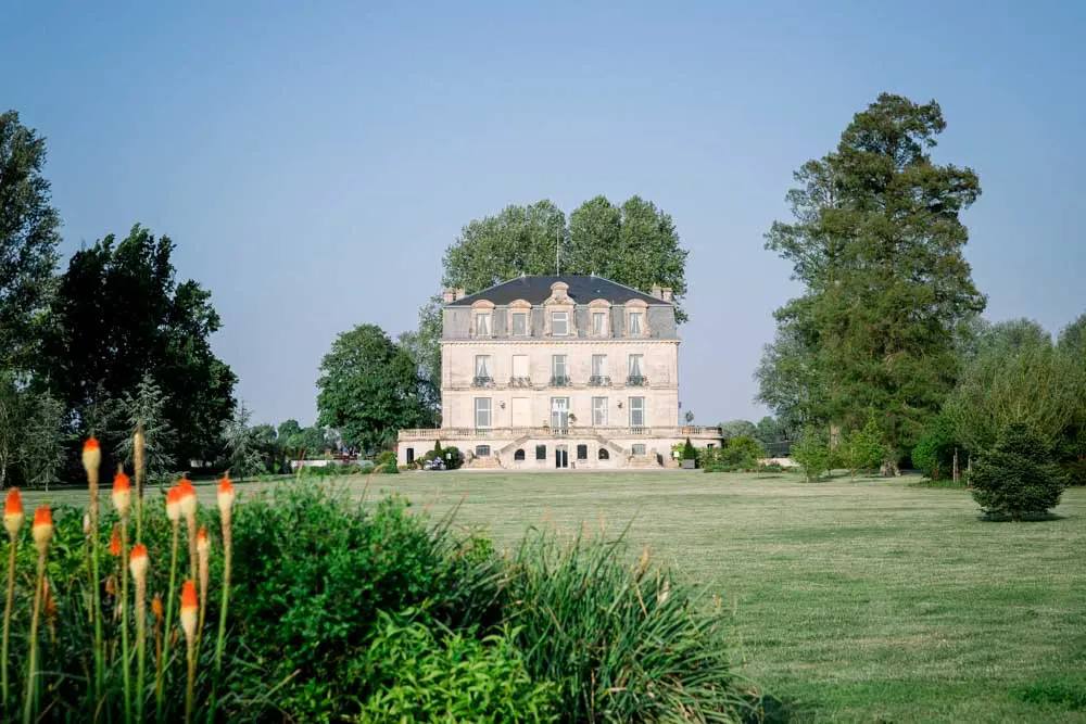 Château Grattequina in Blanquefort seen from its grounds with red-hot pokers in bloom