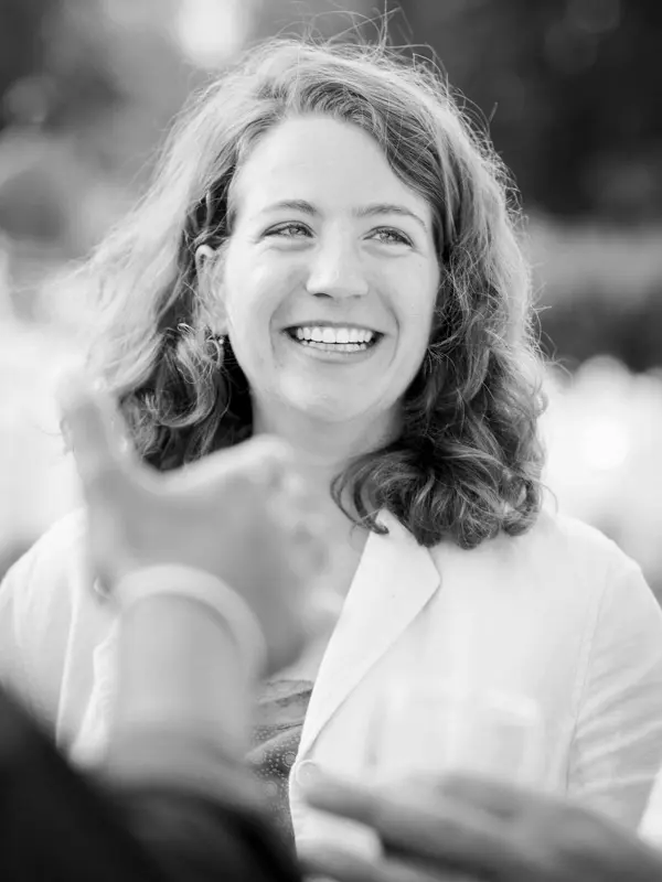 Guest laughing heartily during the wedding cocktail hour, in black and white