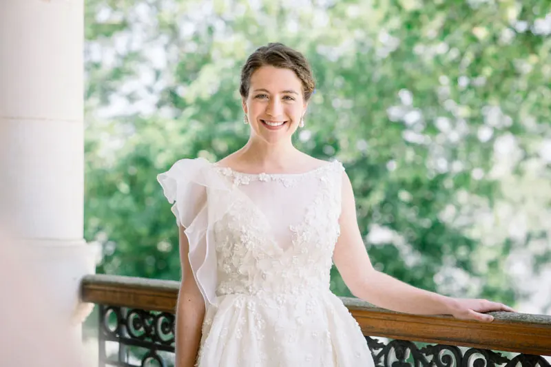 Victoire, the bride, smiling in her lace gown on the château terrace