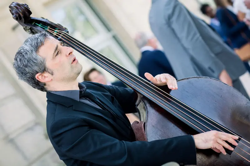 Double bass player performing during the wedding cocktail hour at Château Grattequina