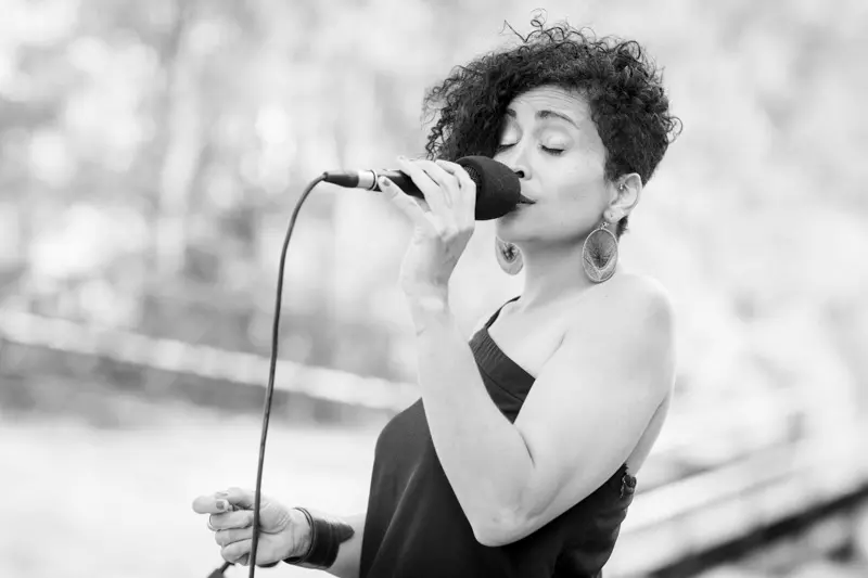 Singer at the microphone during the wedding cocktail hour, in black and white