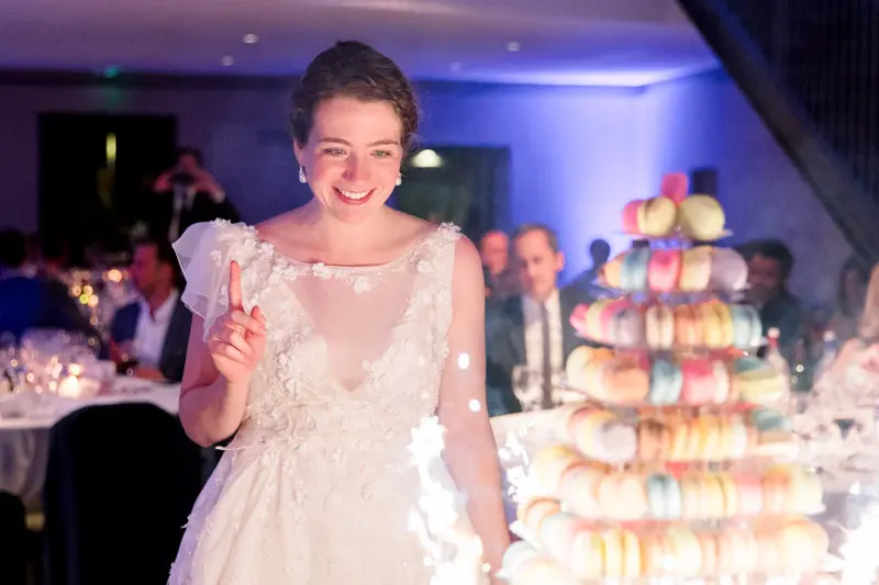 The bride beside the tower of colourful macarons during dinner