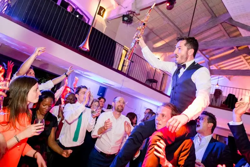 The groom carried shoulder-high by his friends on the dance floor
