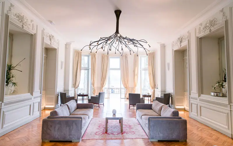 Drawing room at Château Grattequina with a designer chandelier and grey sofas