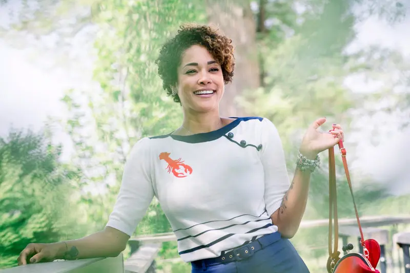 Smiling guest in a lobster-embroidered striped top at the wedding in Blanquefort