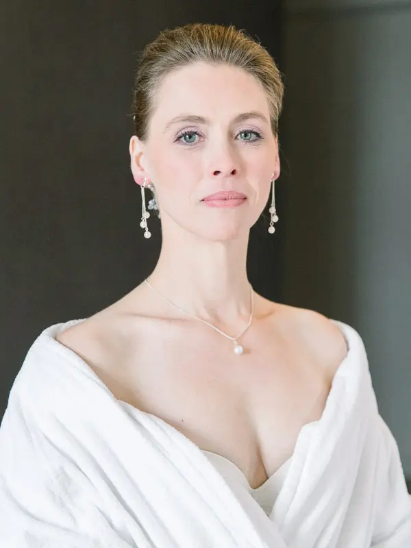 Portrait of the bride in a white stole and drop earrings
