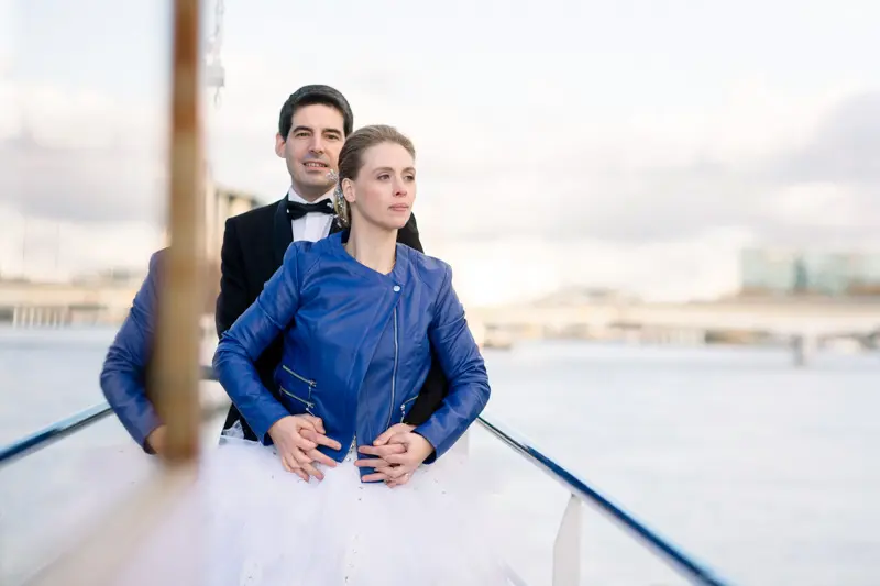 Bride and groom at the bow of the boat cruising on the Seine