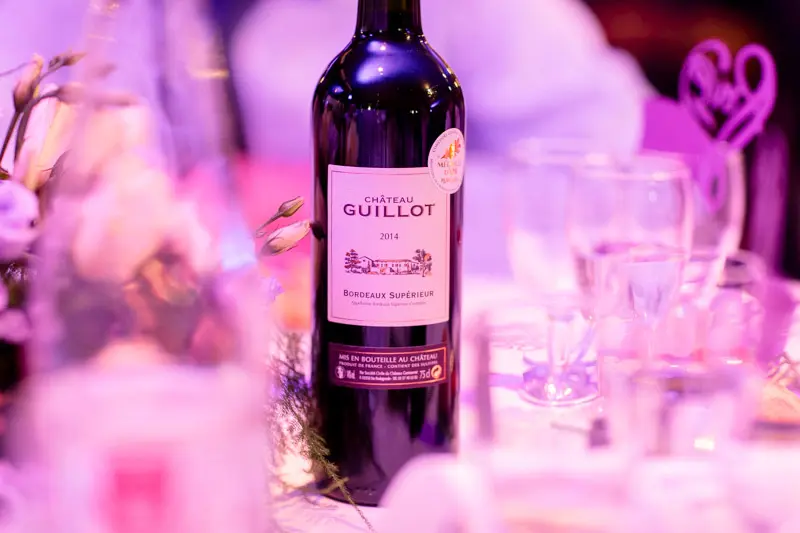 Bottle of red wine on a wedding table under pink light