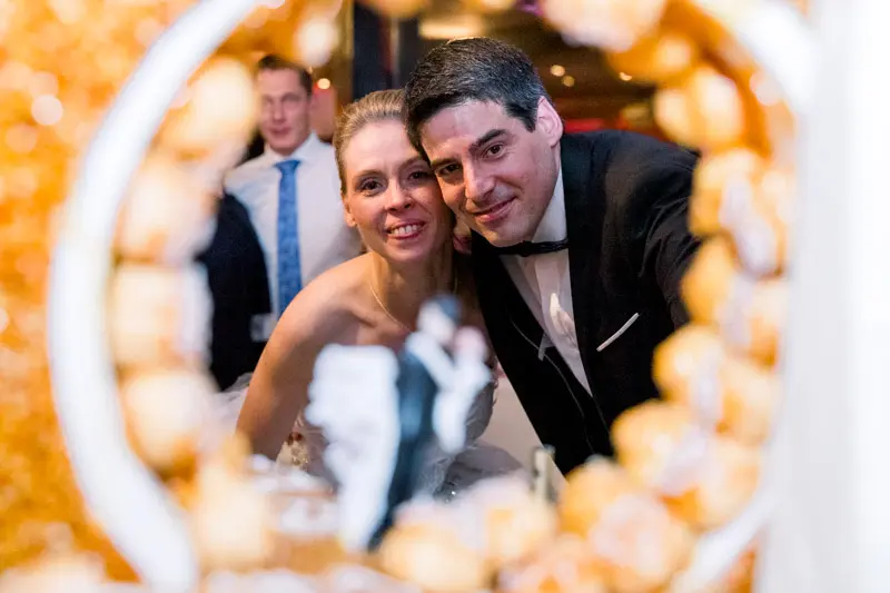 Bride and groom seen through the croquembouche during dessert