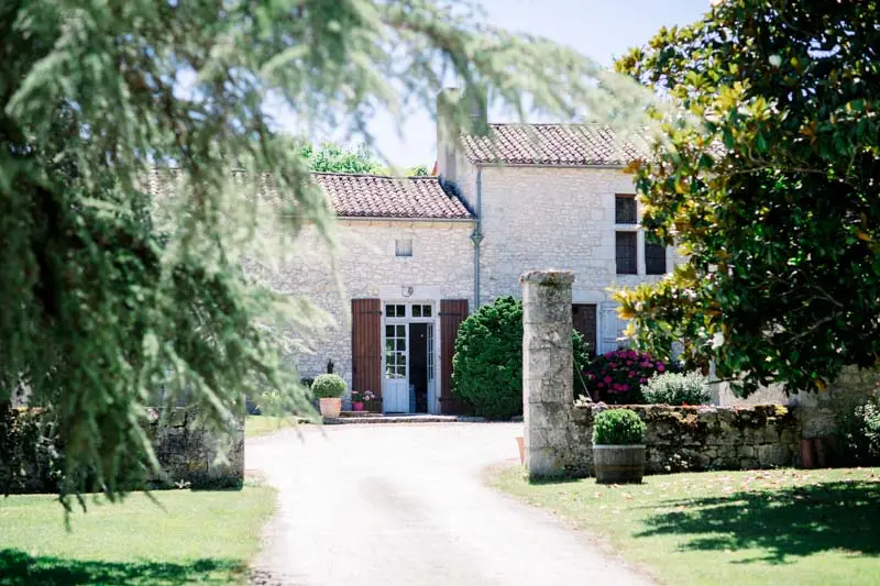 Stone house and its shaded driveway, setting of the country wedding