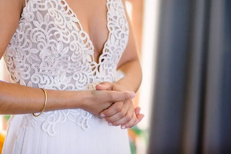 Detail of the lace bodice of the wedding dress, hands clasped