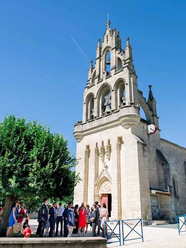 Guests outside the Saint-Pierre church in Les Lèves-et-Thoumeyragues under blue sky