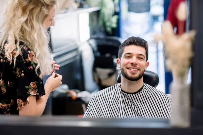 Smiling groom at the barber's getting ready in Chartrons