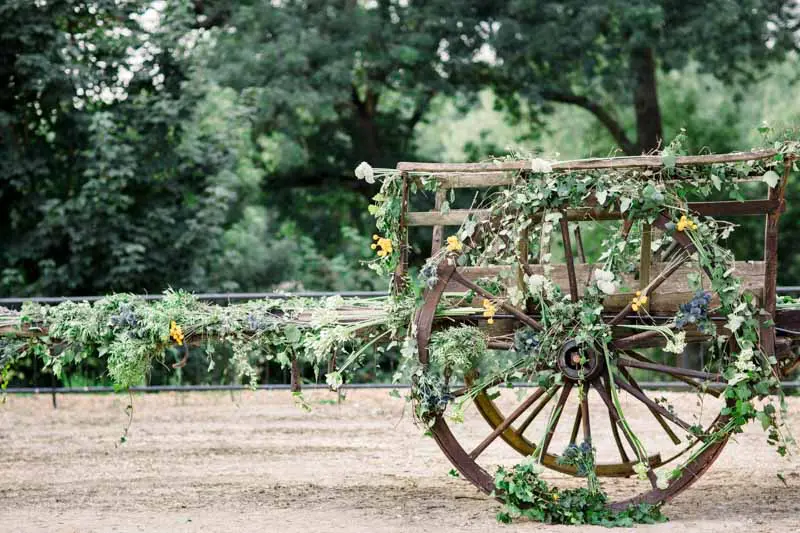 Old cartwheel decorated with foliage and flowers on the gravel