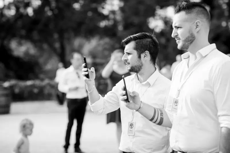 Guests filming the musical surprise on their phones, in black and white