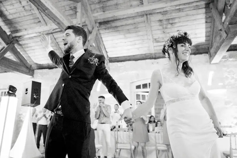 The couple's triumphant entrance into the reception hall, black and white