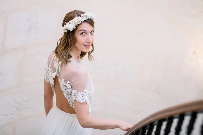 Tiphaine, the bride, in a lace-back gown and flower crown at Villa Victor Louis