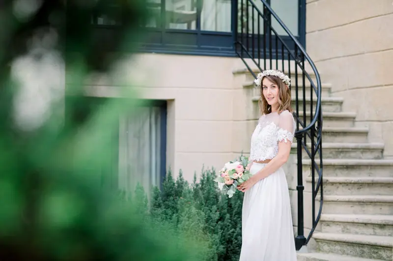 The bride at the foot of the wrought-iron staircase at Villa Victor Louis in Bordeaux