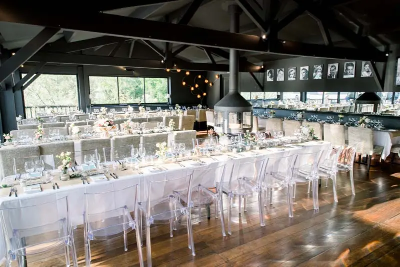 Reception hall at La Maison du Fleuve set with long white tables