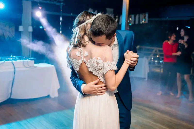 The couple's first dance under blue spotlights at La Maison du Fleuve
