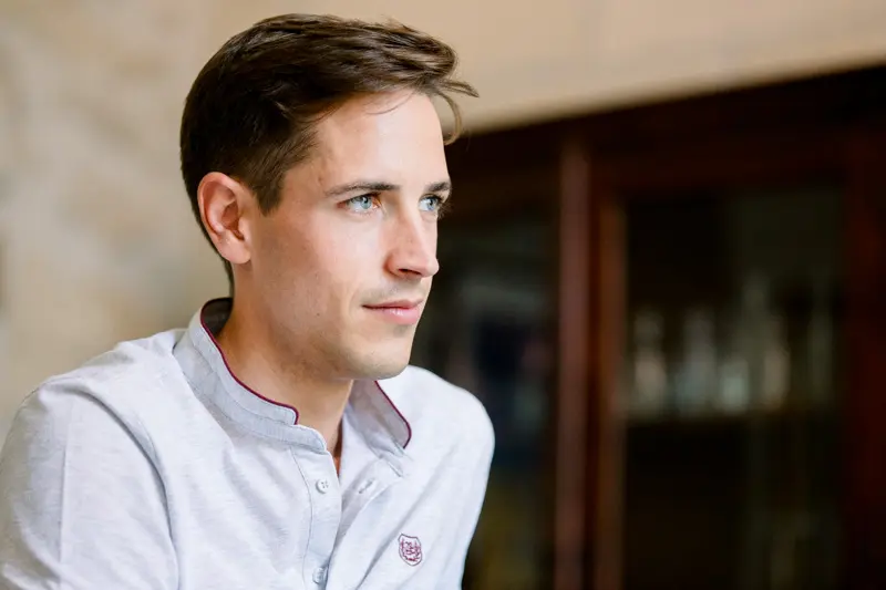 Groom in a white shirt gazing into the distance on the wedding morning