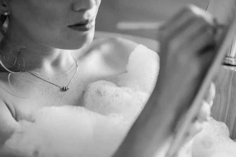 Bride writing in her bath, black and white detail