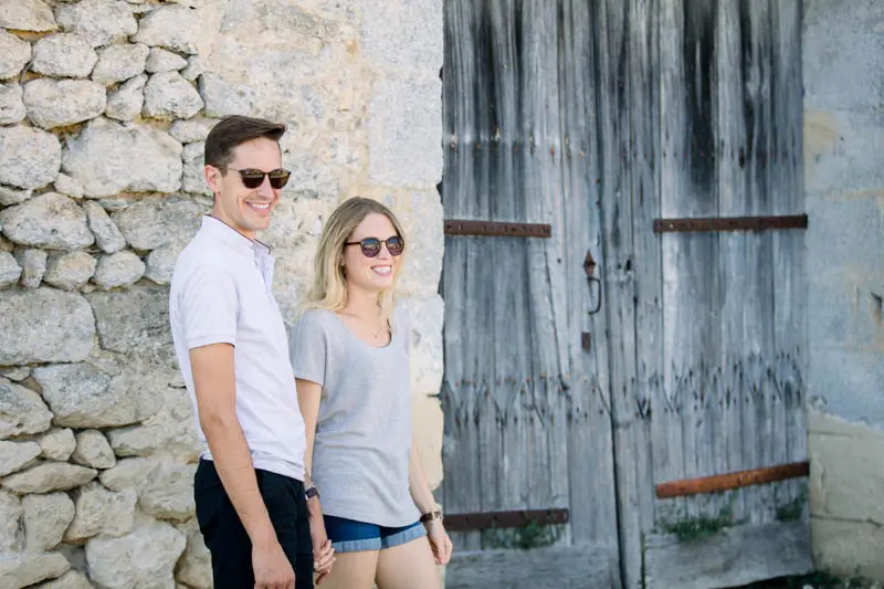Eugénie and Robin in sunglasses in front of an old wooden door