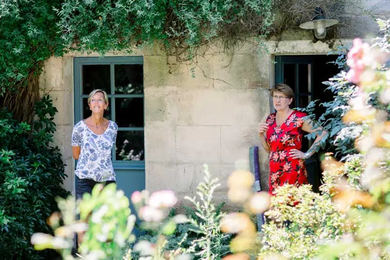 The bride's family on the doorstep of a flower-filled stone house
