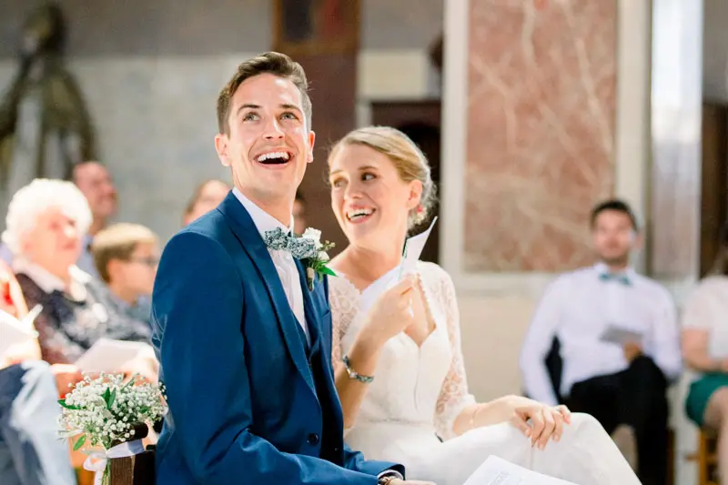 Bride and groom smiling and looking up during the service at Saint-Martial