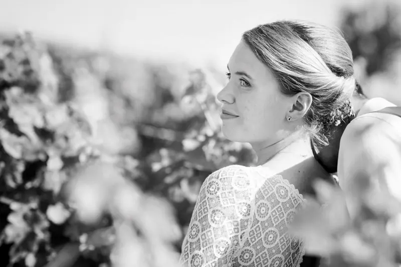 Bride gazing into the distance in the vineyard, in black and white