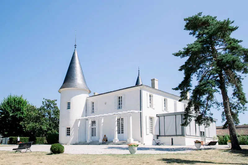 Château de Seguin with its turret and white façade under a blue sky
