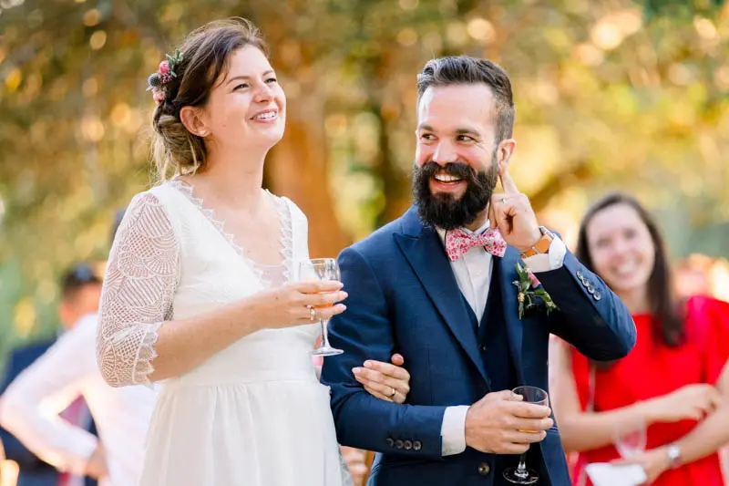 The newlyweds laughing during the cocktail speeches in golden light