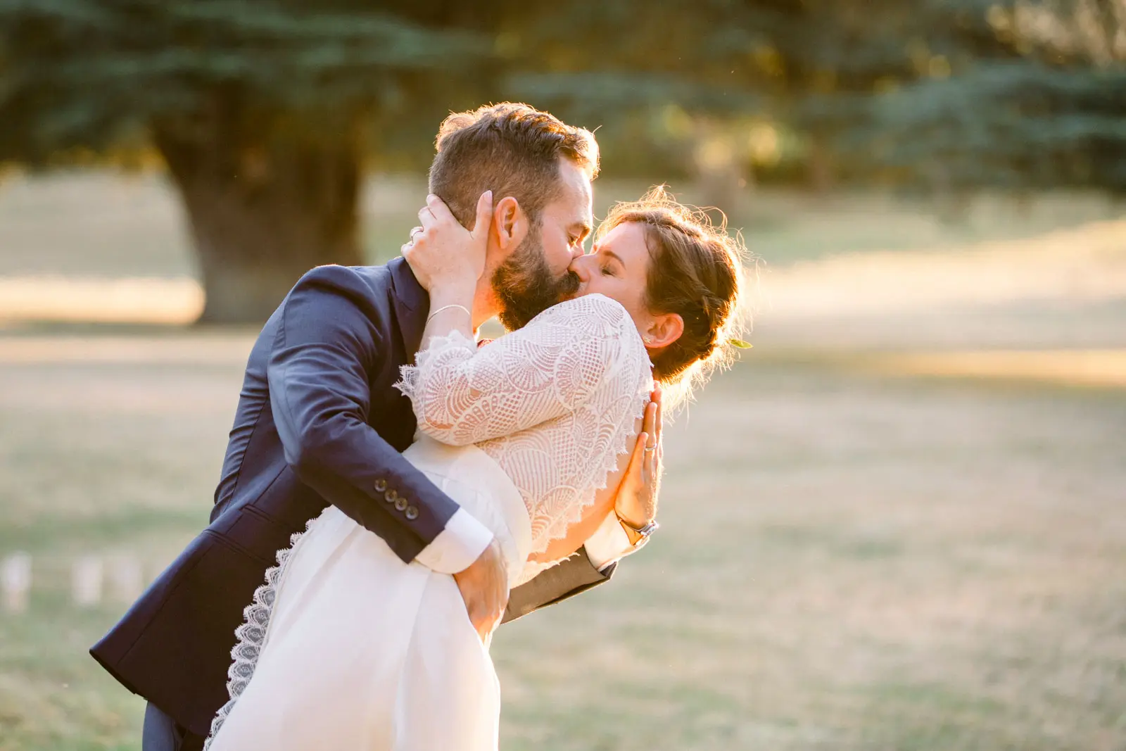 The groom lifts and kisses the bride in the grounds of Château de Seguin