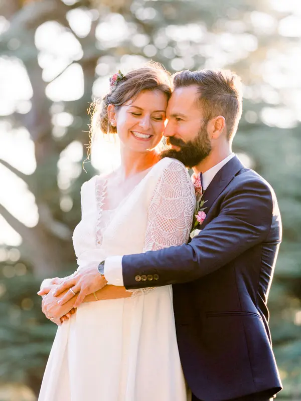 Bride and groom embracing in the sunlight, Château de Seguin