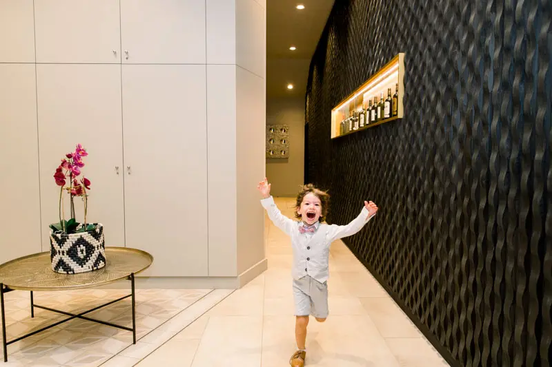 Little boy running joyfully down a château corridor during the party