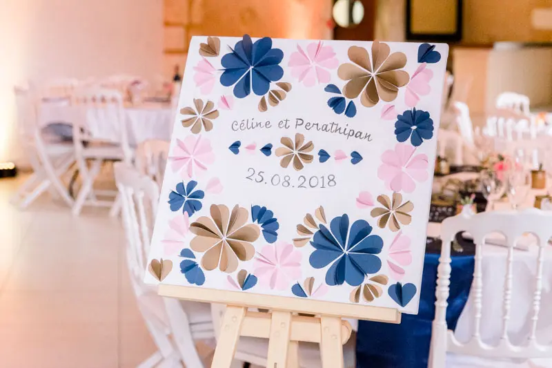 Seating plan with blue and pink paper flowers on an easel