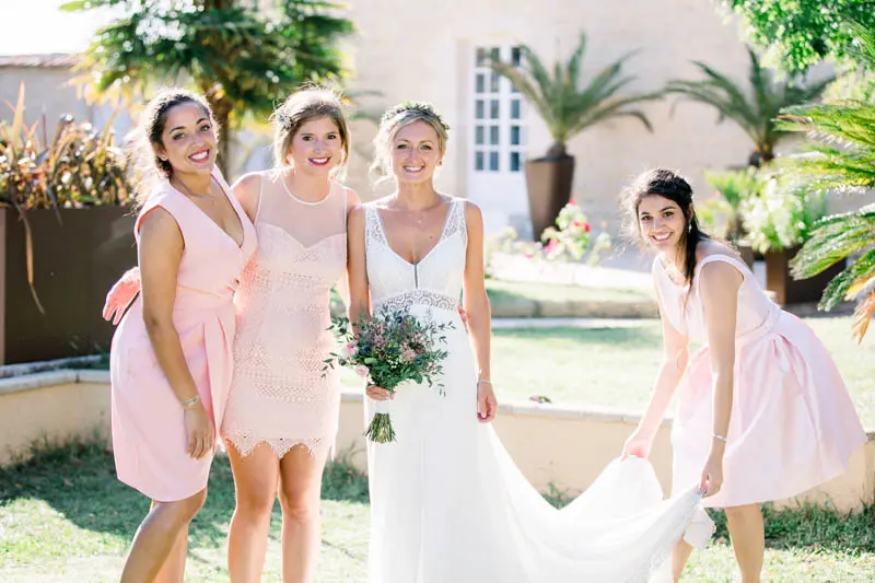 The bride and her bridesmaids in pink dresses in the château garden