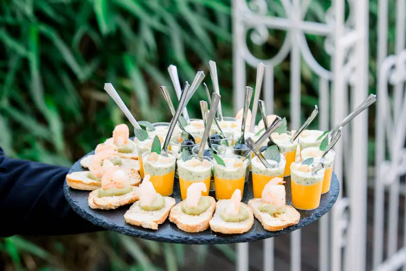 Tray of canapés and colourful verrines served to guests