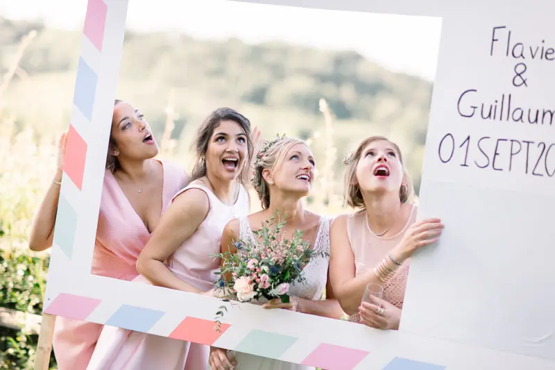 The bride and her friends pose in the “Flavie & Guillaume” photo booth frame