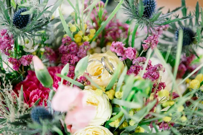 Close-up of the bride's bouquet of roses, blue thistles and ranunculus