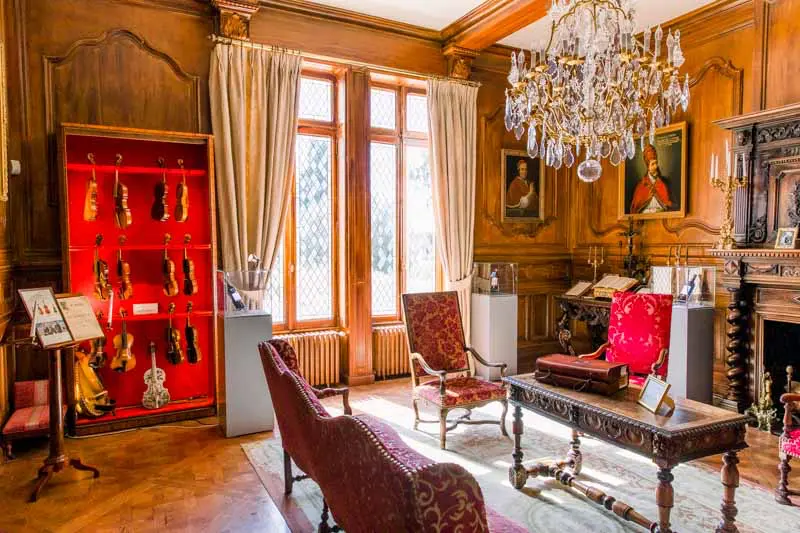The Pope's drawing room with wood panelling and chandelier at Château Pape Clément
