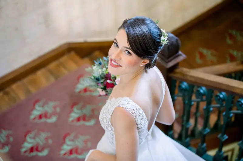 The bride turning with a smile on the staircase at Château Pape Clément