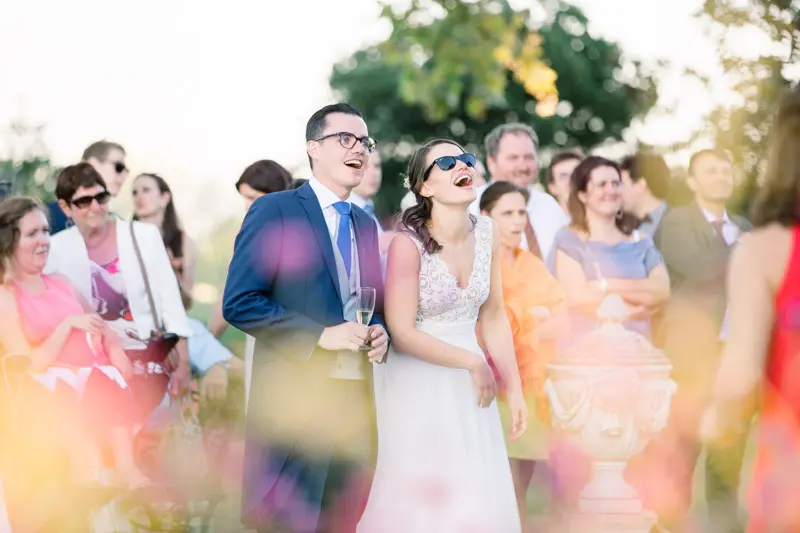 The newlyweds in sunglasses watching the flash mob with their guests