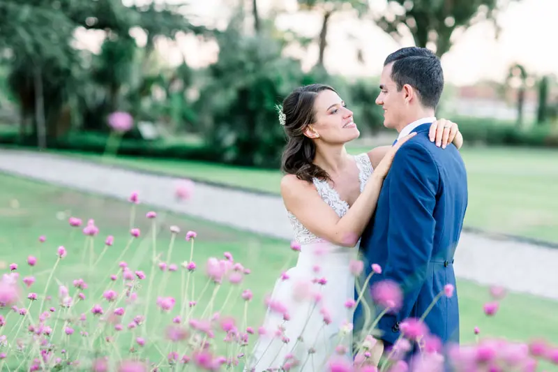 Floride and Benjamin embracing in the grounds of Château Pape Clément, pink flowers in the foreground