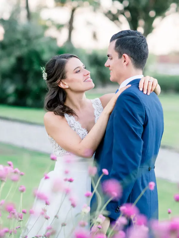 Bride and groom embracing and smiling in the park at sunset