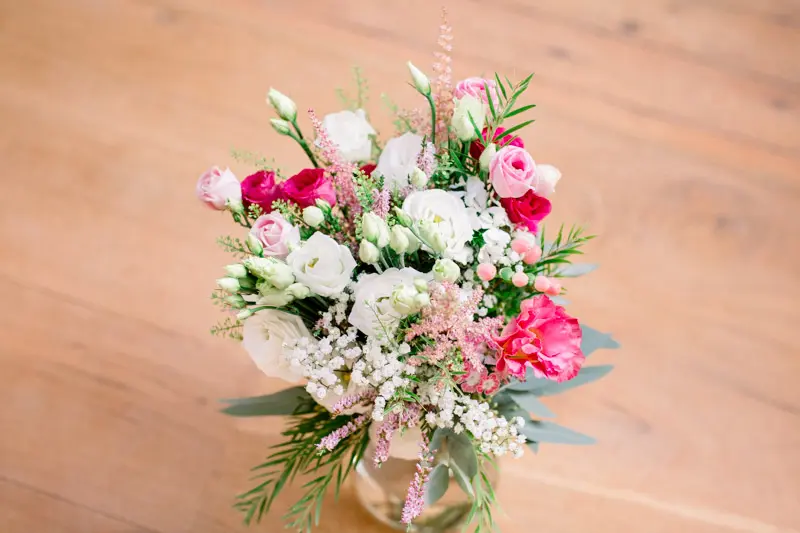 Pink and white bridal bouquet resting on a wooden floor
