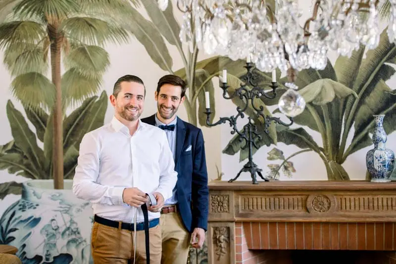 The groom and a friend getting ready by the salon fireplace